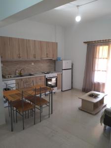 a kitchen with a table and chairs in a room at KASTRO APARTMENTS in Mirina