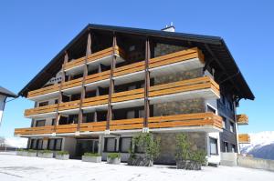 un edificio con balcones de madera en un lateral en Immeuble Panorama, en Les Collons
