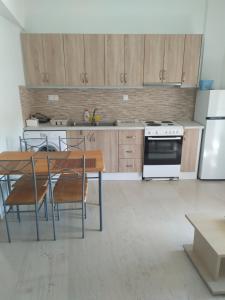 a kitchen with a table and chairs and a refrigerator at KASTRO APARTMENTS in Mirina
