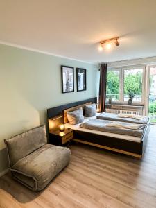 een grote slaapkamer met een bed en een stoel bij Apartment für 3 Gäste mit kostenlosen Parkplätzen und Lift in Hannover
