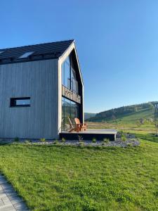 ein kleines Haus mit einem großen Fenster auf einem Feld in der Unterkunft Bieszczadzka Stodoła in Ustrzyki Dolne