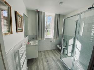 een badkamer met een douche, een wastafel en een toilet bij Manoir de Daubeuf in Daubeuf-Serville