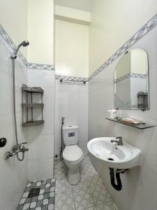a bathroom with a sink and a toilet and a mirror at ARYE guest house in Ấp Lợi Ðủ
