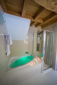 a bathroom with a green tub in a room at Casa Juancito in Santiago de Compostela