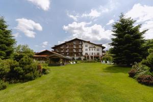 a large building with a large lawn in front of it at Alpejski Boutique Hotel in Karpacz