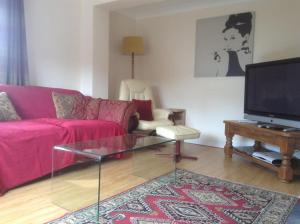 a living room with a pink couch and a tv at Lynn Cottage, Newport in Newport