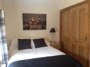 a bedroom with a bed and a painting on the wall at Lynn Cottage, Newport in Newport