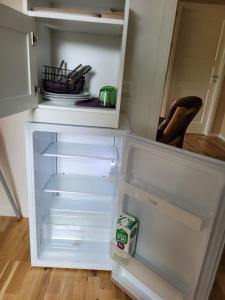 an empty refrigerator with its door open in a kitchen at Frillesås BB Vallersvik in Frillesås