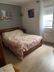 Un dormitorio con una cama con flores rosas. en Loue maison quartier calme, en Royan