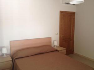 een slaapkamer met een bed en twee nachtkastjes met twee lampen bij Casa Panoramica in Nizza di Sicilia