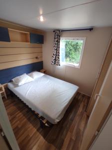 a bedroom with a large bed and a window at Camping la Grangeonne in Esparron-de-Verdon