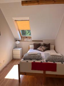 a attic bedroom with a bed and a window at Dom w Rzeczce Góry Sowie in Rzeczka