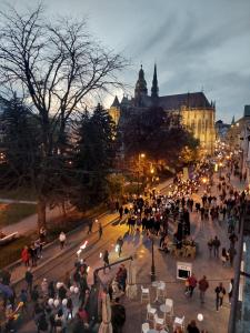 una multitud de personas caminando en una calle de la ciudad por la noche en PADRE PIO APARTMENTS MINI, en Košice