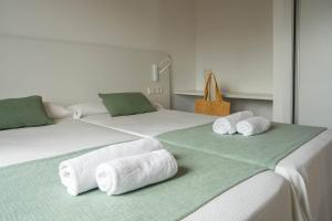 zwei Betten mit Handtüchern darüber in der Unterkunft Villas Rymar in Cala'n Bosch