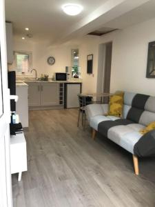 a living room with a couch and a kitchen at Dolly Cottage Colchester in Mile End