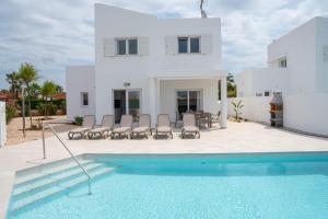 a villa with a swimming pool in front of a house at Villas Rymar in Cala'n Bosch