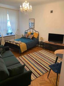 sala de estar con cama y lámpara de araña en Warsaw Mermaid Apartment - Ideal place for You, en Varsovia
