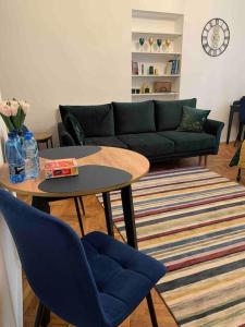 Warsaw Mermaid Apartment - Ideal place for You في وارسو: غرفة معيشة مع أريكة وطاولة