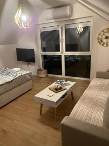 Vista apart Pluzine في بلوزين: غرفة معيشة مع سرير وطاولة قهوة