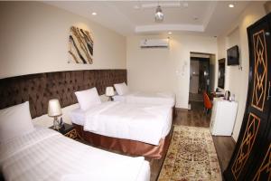 a hotel room with two beds and a television at فندق المربع السابع Seventh Square Hotel in Makkah