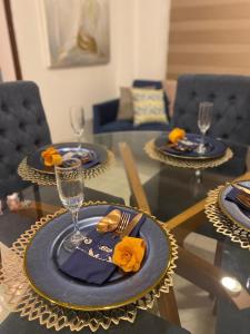 mesa de comedor con platos y tenedores azules y servilletas en Lujo, mar, seguridad y diversión en la mejor zona de Manta., en Manta