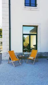 deux chaises assises devant un bâtiment dans l'établissement La Gare Soyons, à Soyons