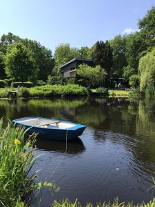 a blue boat sitting in the middle of a river at Moorgalerie in Edewecht