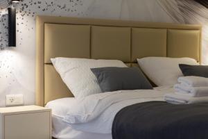 1 dormitorio con 1 cama grande con sábanas y almohadas blancas en Apartment Kirinkin, en Vis