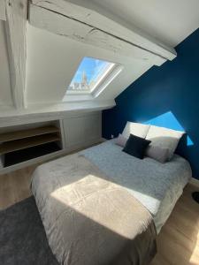 een slaapkamer met een groot bed en een raam bij Studio moderne en plein centre de Caen in Caen
