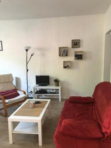 歐波納的住宿－Karinou，客厅配有红色沙发和茶几