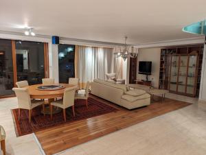 un soggiorno con tavolo e divano di Luxury Breathtaking Seafront Penthouse Duplex a Rishon LeẔiyyon