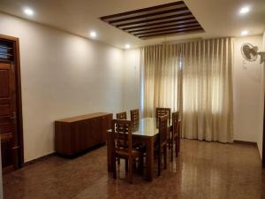 a dining room with a table and chairs at Nandhanam Holidays in Kannur