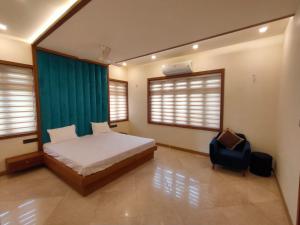 a bedroom with a bed and a chair in it at Nandhanam Holidays in Kannur