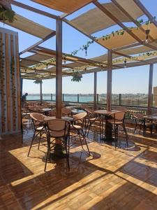 ein Restaurant mit Tischen und Stühlen auf einer Terrasse in der Unterkunft RED SEA HOTEL - فندق ريد سى in Suez