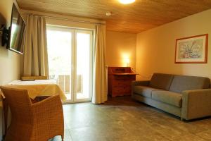 ein Wohnzimmer mit einem Sofa und einem Fenster in der Unterkunft Gästehaus Hornstein in Nonnenhorn