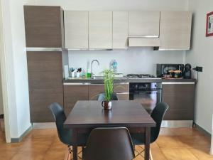 a kitchen with a wooden table with chairs and a sink at Home of Fame - home gallery with fully equipped kitchen, separate entrance, free parking - IUN F3158 in Olbia