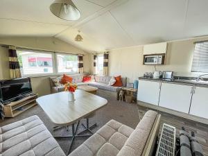 sala de estar con mesa y cocina en Lovely 6 Berth Caravan With Decking, Close To The Beach In Suffolk Ref 68075bs en Lowestoft