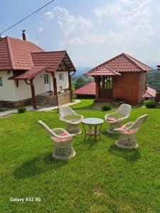 un grupo de sillas y una mesa en un patio en Etno selo EKO POGLEDI en Požega