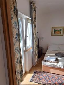 Schlafzimmer mit einem Bett, einem Fenster und einem Teppich in der Unterkunft Apartments Panonija in Novalja