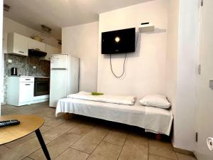 a kitchen with a bed with a tv on the wall at Familly Apartament 5 in Międzyzdroje
