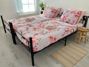 łóżko z różowymi kwiatami w sypialni w obiekcie Bed & Stay Kersenbloesem w mieście Nijswiller