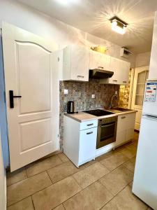 una cucina con armadietti bianchi e una porta bianca di Familly Apartament 5 a Międzyzdroje