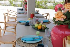 a long table with blue plates and a vase of fruit at Maggana Residence in Minia