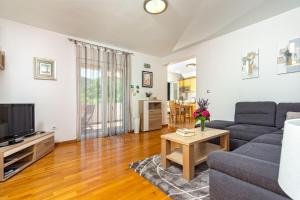 a living room with a couch and a tv at Apartment Mandalina House in Stari Grad