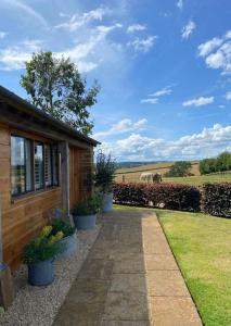 a house with potted plants next to a building at Luxury & comfort in the Cotswolds in Banbury