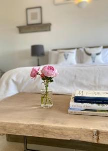 un vase de fleurs sur une table avec des livres dans l'établissement Stunning 'Room with a view', à Banbury