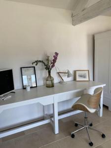 a white desk with a vase of flowers and a chair at Luxury & comfort in the Cotswolds in Banbury