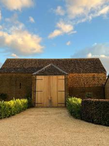 a brick building with a large wooden garage at Stunning 'Room with a view' in Banbury