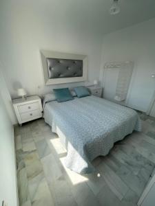 una camera da letto con un grande letto con cuscini blu di Apartamento Jardines del Rocío a Torre del Mar