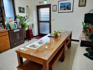 einen großen Holztisch im Wohnzimmer in der Unterkunft Happy Inn in Juguang